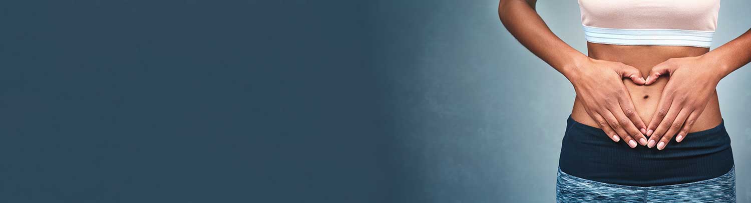 Picture of a woman with her hands on her stomach, forming a heart