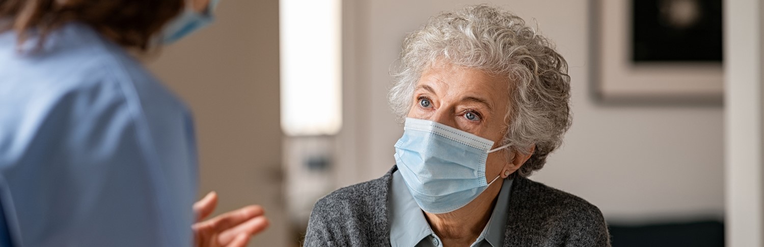 A photo of a older female patient speaking to a doctor