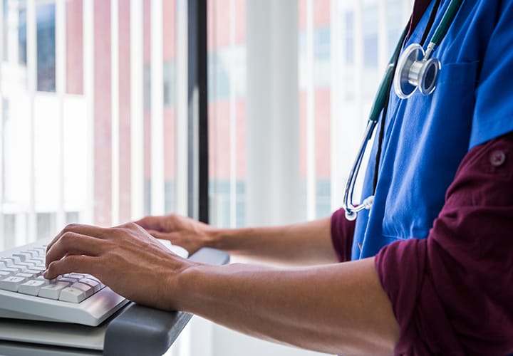 Picture of a health professional typing on the keyboard