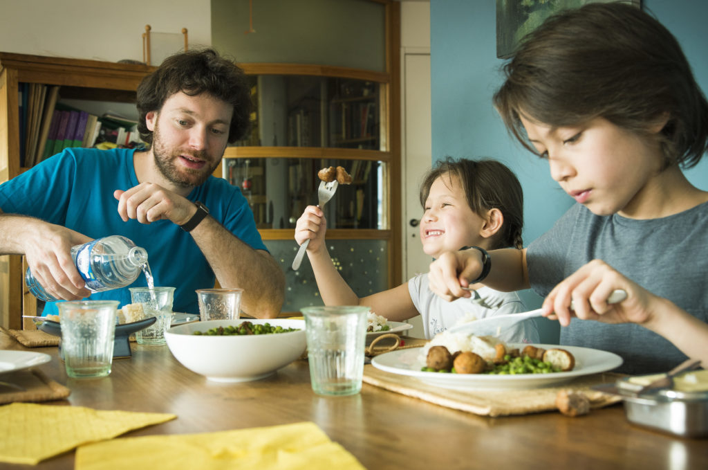 Children enjoying their meal with a parent