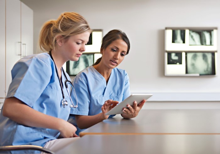 Nurses examining charts; ?>
