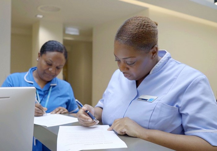 Two nurses completing paperwork; ?>