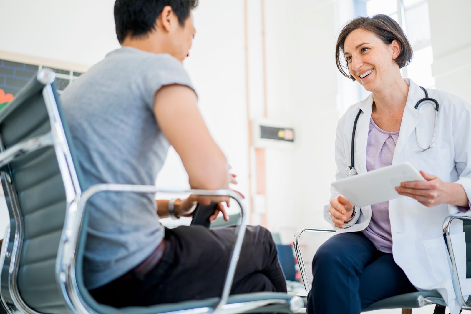 Picture of a doctor and patient smiling during consultation