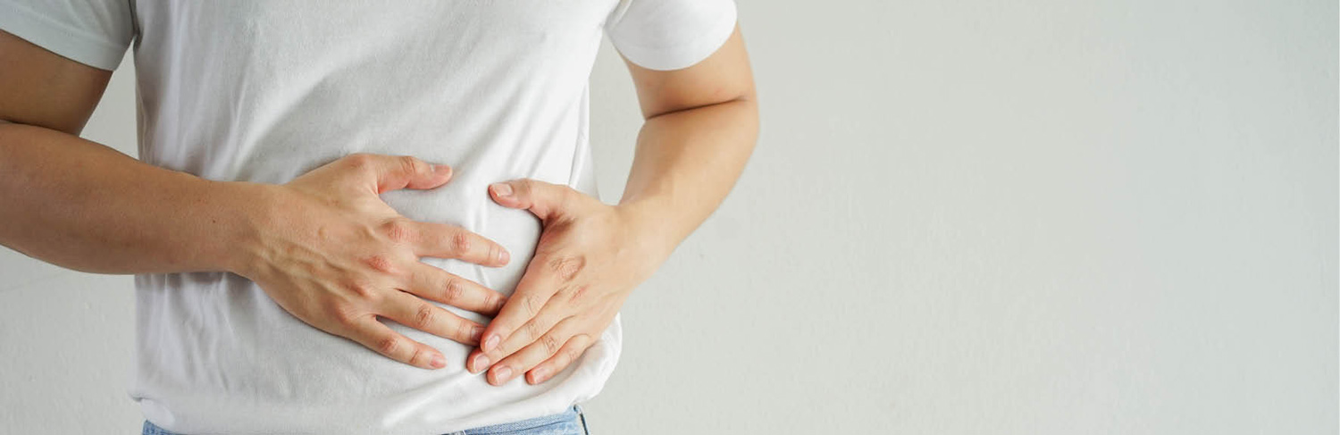 A photo of a man holding on to lower part of his stomach