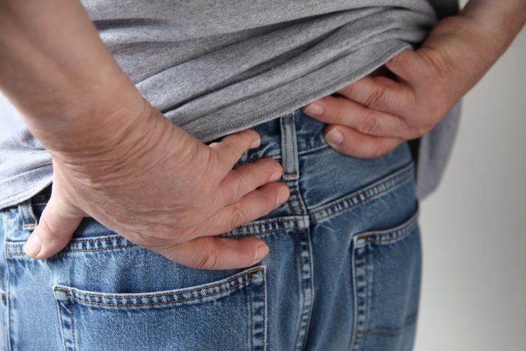 Picture of a man touching lower part of his back