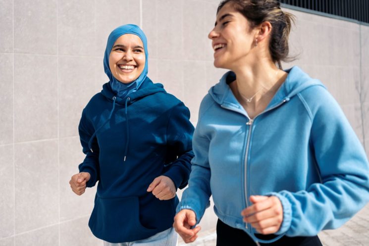 Picture of two women running together and laughing