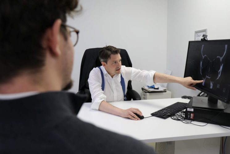 Picture of a consultant showing his patient results of a scan
