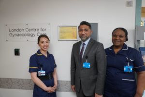 A picture of Amer Raza with nurses next to award