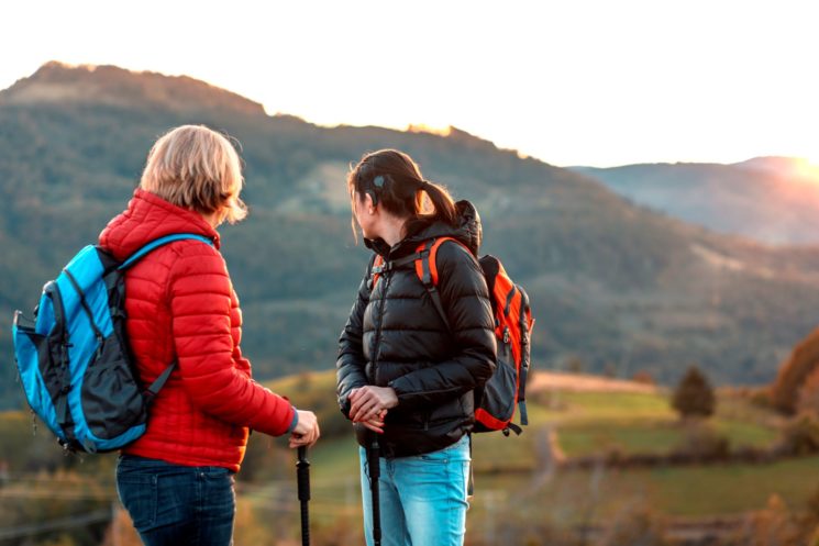 Two women are hiking, one wearing a cochlear implant